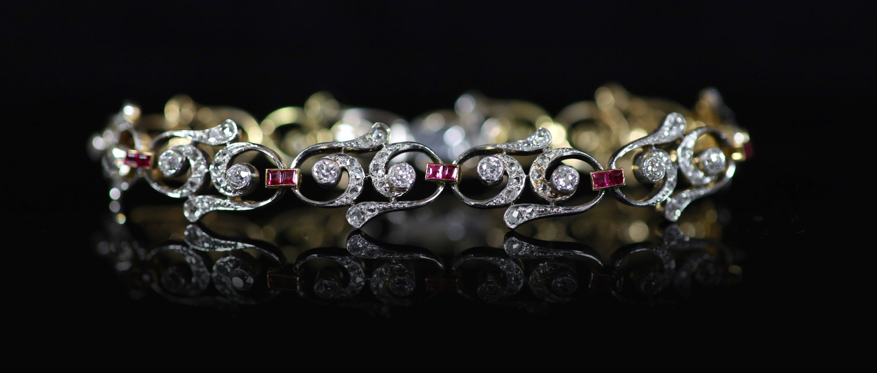 A 1940's/1950's gold and platinum, ruby and diamond set open work scroll link bracelet